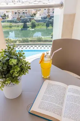 an open book sitting on a table next to a plant at The Navigator - Solaqua in Albufeira