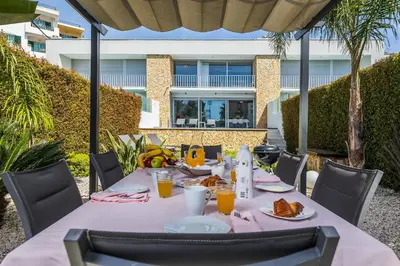 a table with food and orange juice on a patio at Design Villa Pascoal in Albufeira