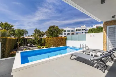 a view of a swimming pool and a patio with two chairs at Design Villa Pascoal in Albufeira