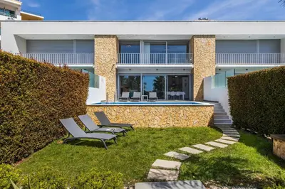 a house with two chairs and a swimming pool at Design Villa Pascoal in Albufeira