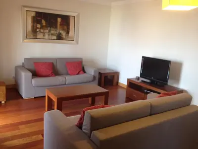 a living room with a couch and a tv at Corcovada, Albufeira, Algarve in Albufeira