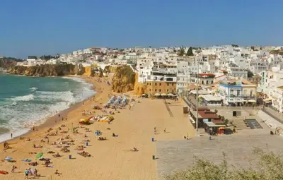 a group of people on a beach near the ocean at Corcovada, Albufeira, Algarve in Albufeira