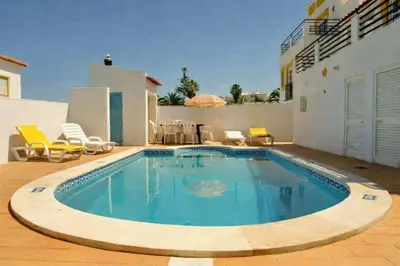 a swimming pool in front of a house at Villa V4 com Piscina Privada a 400 metros da Praia in Albufeira