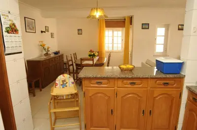 a kitchen with a counter and a dining room at Villa V4 com Piscina Privada a 400 metros da Praia in Albufeira