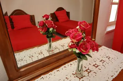 two vases with roses on a table in front of a mirror at Villa V4 com Piscina Privada a 400 metros da Praia in Albufeira