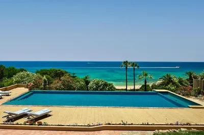 a swimming pool with a view of the ocean at Vila Joya in Albufeira