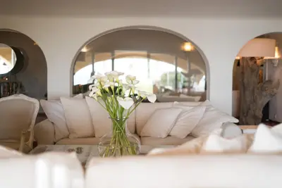 a living room with a white couch and a vase of flowers at Vila Joya in Albufeira