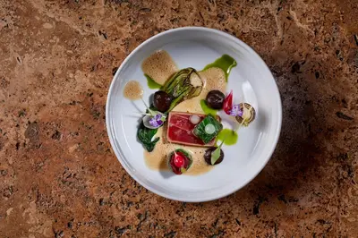 a white plate with food on a table at Vila Joya in Albufeira