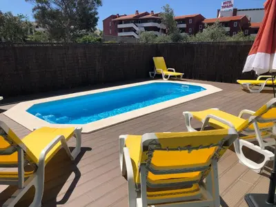 a swimming pool with two chairs and a table and two chairsemn at Spacious house with private pool in Albufeira in Albufeira