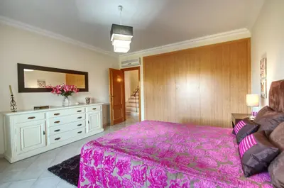 a bedroom with a pink bed and a dresser at Spacious house with private pool in Albufeira in Albufeira