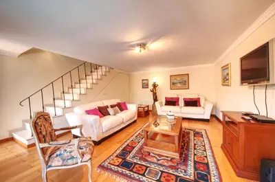 a living room with white furniture and a staircase at Spacious house with private pool in Albufeira in Albufeira
