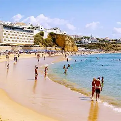 a group of people walking on a beach at Spacious house with private pool in Albufeira in Albufeira