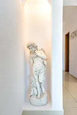 a statue of a woman holding a bird in a hallway at Camilla apartment in Albufeira