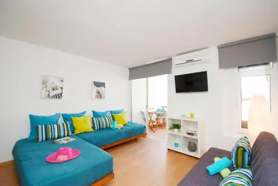 a living room with a blue couch and a tv at Apartment Marbella by Algarve Vacation in Albufeira