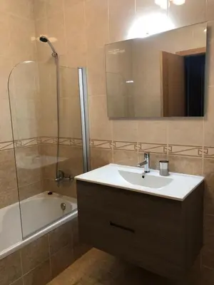 a bathroom with a sink and a shower with a mirror at Holiday Duplex Alto dos Salgados in Albufeira