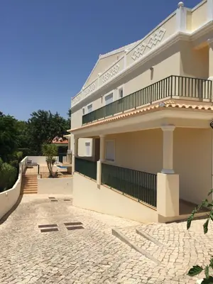 a large white building with a balcony on top at Holiday Duplex Alto dos Salgados in Albufeira