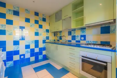 a kitchen with blue and yellow tiles on the wall at Apartamentos da Orada by Garvetur in Albufeira