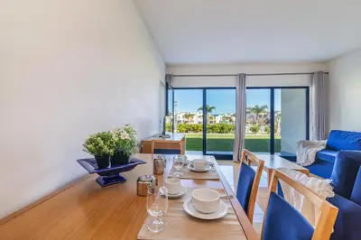 a living room with a table and a blue couch at Apartamentos da Orada by Garvetur in Albufeira