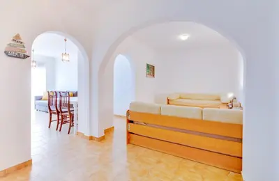 a living room with a bed and a dining room at AL - Apartamento Girassol in Quarteira