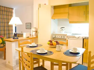 a kitchen with a wooden table and a dining room at Apartamentos Edificio Albufeira - Alojamento Local in Albufeira