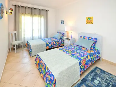 a bedroom with two beds and a chair at Bogart at Casablanca by OCvillas in Albufeira