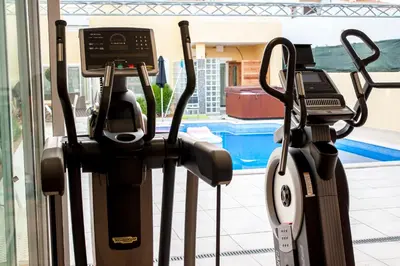 a gym with two exercise machines next to a pool at villa Aqua-Jacuzzi-heatable pool-sauna-gym-snooker in Albufeira