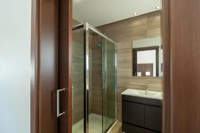 a bathroom with a glass shower and a sink at villa Aqua-Jacuzzi-heatable pool-sauna-gym-snooker in Albufeira