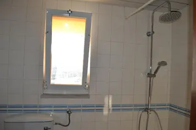 a bathroom with a shower and a toilet and a window at TP MARINA 27, Vilamoura View Apartment in Quarteira