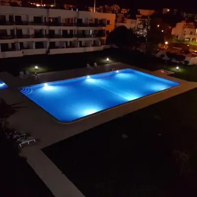 a swimming pool at night on a building at Hello Sun in Vilamoura