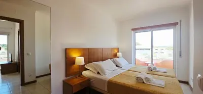 a bedroom with a large bed with towels on it at Falesia Beach Apartment in Albufeira
