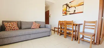 a living room with a couch and a table and chairs at Falesia Beach Apartment in Albufeira
