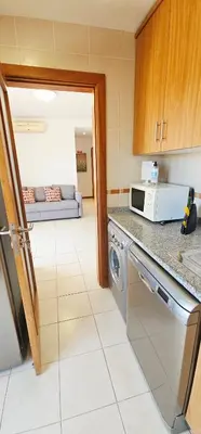 a kitchen with a stove and a microwave at Falesia Beach Apartment in Albufeira