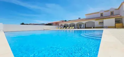 a swimming pool in front of a house at Falesia Beach Apartment in Albufeira