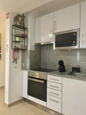 a kitchen with white cabinets and a black oven at Bayview Apartment 213 in Albufeira