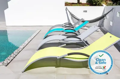 a group of chairs sitting next to a pool at Luxury 47 in Albufeira