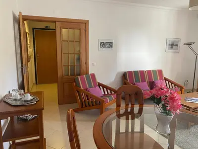 a living room with two chairs and a glass table at Nice apartment near Faro's airport in Faro