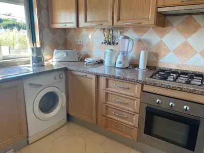 a kitchen with a stove and a washing machine at Nice apartment near Faro's airport in Faro