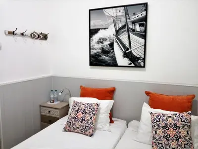 a room with a bed and a picture of a boat at Faro Cosy Guesthouse in Faro