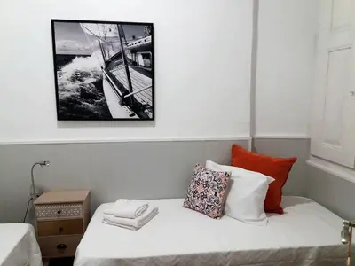 a bed in a room with a picture on the wall at Faro Cosy Guesthouse in Faro