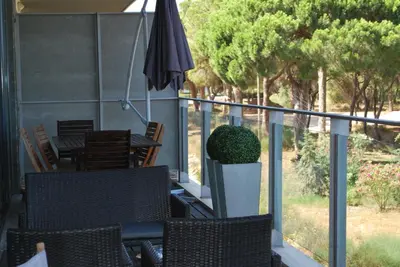 a patio with a table and chairs and an umbrella at Golf Residence Apartment in Vilamoura