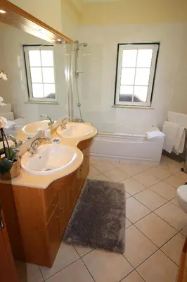 a bathroom with two sinks and a bath tub at Charming Exceptional Golf Villa in Algarve in Faro