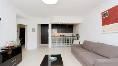 a living room with a couch and a kitchen at Nautilus 135- Clever Details in Vilamoura