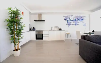a living room with a couch and a kitchen at Paradise Quarteira in Quarteira
