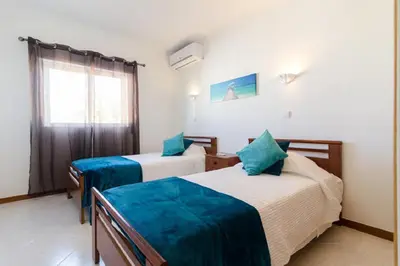 a hotel room with two beds and a window at Albufeira Centrally Located Apartment with Pool View in Albufeira