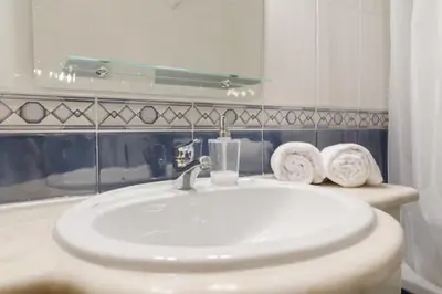 a bathroom with a sink and a mirror and towels at Albufeira Centrally Located Apartment with Pool View in Albufeira