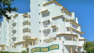 a large white building with a sign in front of it at Albufeira Centrally Located Apartment with Pool View in Albufeira