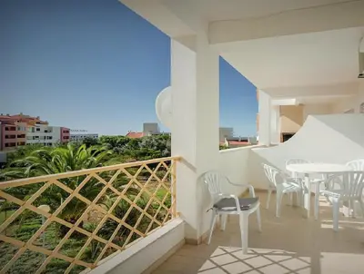 a balcony with a table and chairs and a view at Albufeira Centrally Located Apartment with Pool View in Albufeira