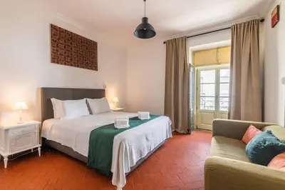 a hotel room with a bed and a couch at Casa dos Arcos - Charm Guesthouse in Albufeira