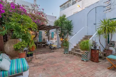 a patio with a bunch of potted plants and stairs at Casa dos Arcos - Charm Guesthouse in Albufeira