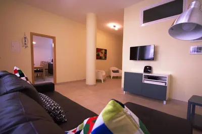 a living room with a couch and a flat screen tv at Apartamentos Plaza - Albufeira in Albufeira